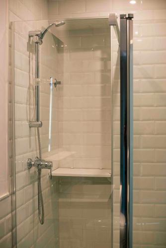 a shower with a glass door in a bathroom at Casa Boutique La Pila del Pato in Seville
