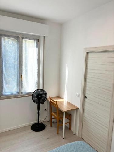 ein Zimmer mit einem Schreibtisch und einem Ventilator neben einem Fenster in der Unterkunft Suite 13 in Pesaro