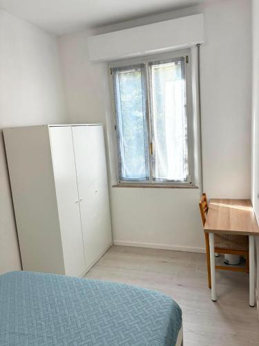 ein Schlafzimmer mit Bett, Fenster und Schreibtisch in der Unterkunft Suite 13 in Pesaro