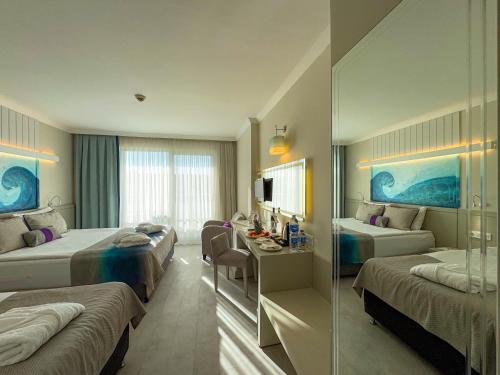 a hotel room with two beds and a desk at Catamaran Quality Times - Premium Ultra All Inclusive in Kemer