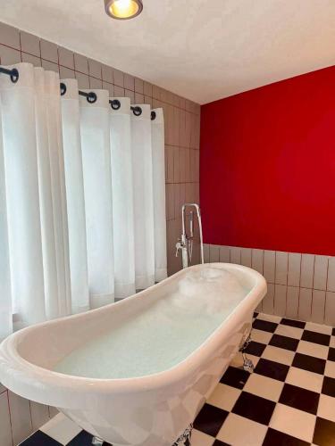 a white bath tub in a bathroom with a red wall at STAY Standard HOTEL Kohlarn in Ko Larn