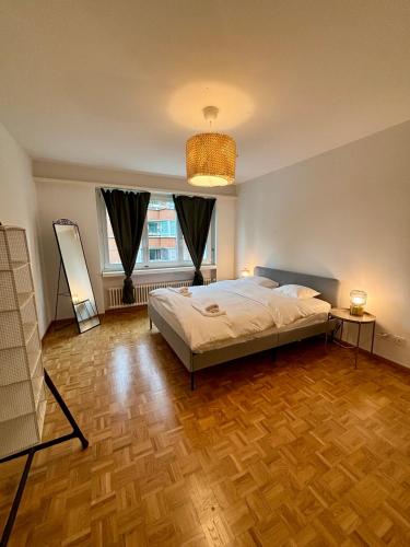 a bedroom with a bed and a wooden floor at Basic Apartment in Witikon district in Zurich
