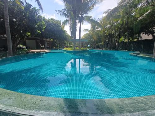 a large blue swimming pool with palm trees in the background at Lagoona Eco Resort Binh Chau in Binh Chau