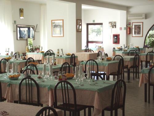 a dining room with tables and chairs with green tablecloths at Hotel Piccolo Paradiso in Peschici