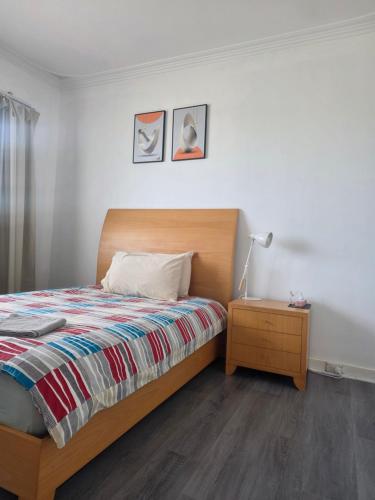 a bedroom with a bed and a table with a lamp at Nice quite stay in Perth