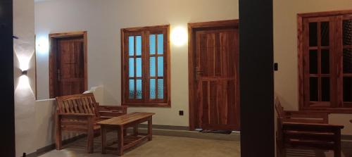 a room with two windows and a wooden chair at Hungry Wave in Arugam Bay