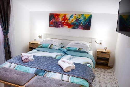 a bedroom with two beds and a painting on the wall at Sunny oasis in Marčelji