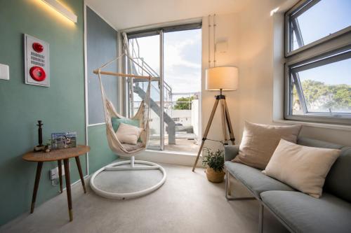 a living room with a swing and a couch at Balmy Ocean OKINAWA in Yomitan