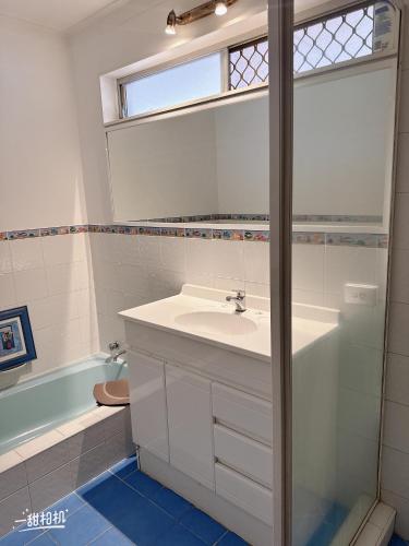 a bathroom with a sink and a mirror and a tub at Nice quite stay in Perth