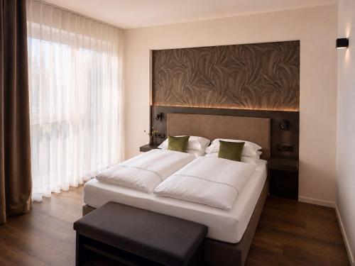 ein Schlafzimmer mit einem großen Bett und einem großen Fenster in der Unterkunft in2 The Hotel in Xanten