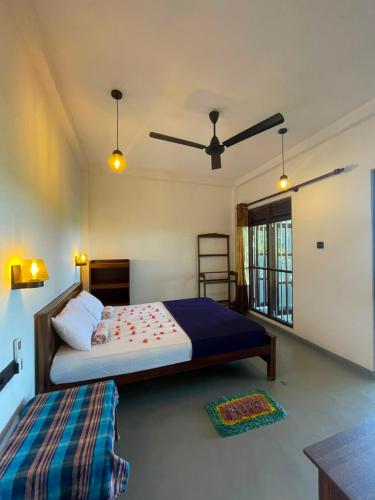 a bedroom with a bed and a ceiling fan at Sasaa Guest House in Mirissa