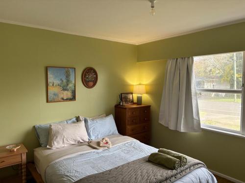 a baby sitting on a bed in a bedroom at Cute Chartwell Cottage in Hamilton
