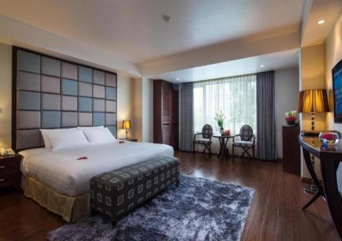 a hotel room with a large bed and a desk at Skylark Boutique and Spa in Hanoi