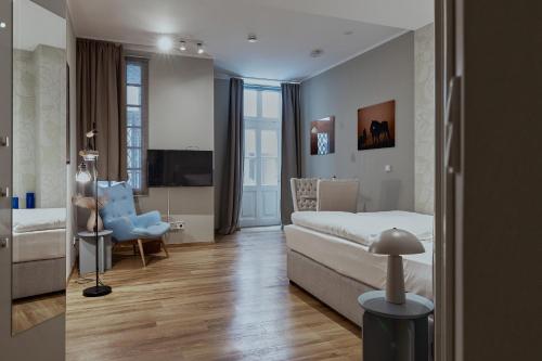 a bedroom with a bed and a chair in a room at Living am Carlsplatz Apartment in Düsseldorf