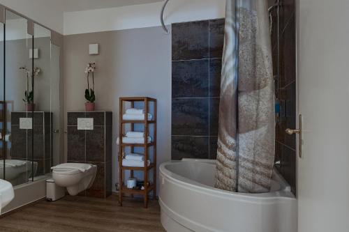 a bathroom with a tub and a toilet and a shower at Living am Carlsplatz Apartment in Düsseldorf