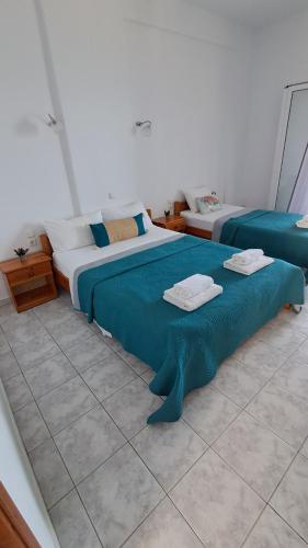 zwei Betten in einem Zimmer mit blau-weißen in der Unterkunft VILLA VRACHOS Preveza in Vráchos
