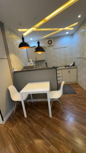 a white table and two chairs in a kitchen at شاليه دار وارف in As Sayl aş Şaghīr