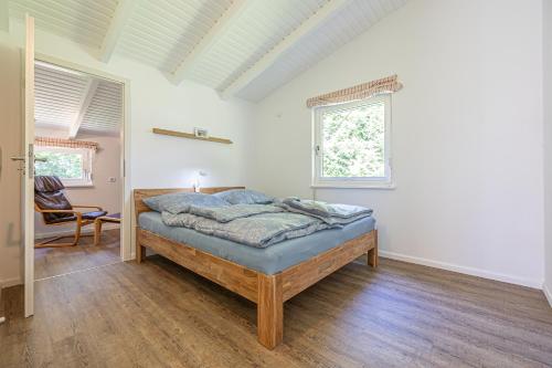 a bedroom with a bed in a white room at Nordisch Nest in Bistensee