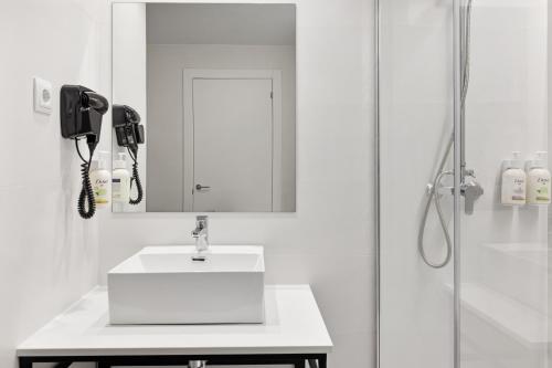 a bathroom with a sink and a mirror and a shower at B&B HOTEL Barcelona Sant Cugat in Sant Cugat del Vallès