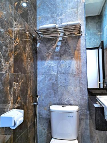 a bathroom with a toilet and a shower and a sink at Raden Wijaya Hotel & Convention in Mojokerto