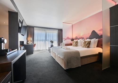 a hotel room with a large bed and a television at Van der Valk Hotel Nuland - 's-Hertogenbosch in Nuland