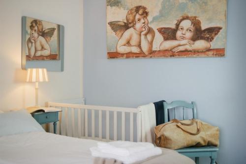 a bedroom with a crib and a painting of angels at Haus Isabel in Büsum