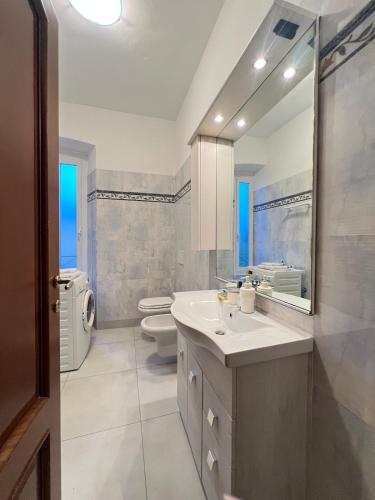 a bathroom with a sink and a toilet and a mirror at Vicino al mare sulla pista ciclabile in Imperia