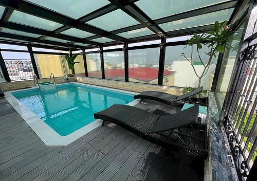 a swimming pool with lounge chairs on a deck at Skylark Boutique and Spa in Hanoi