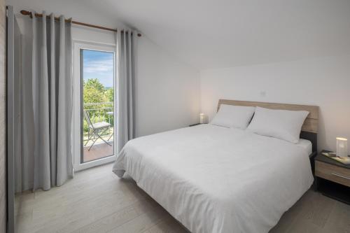 a bedroom with a bed and a large window at Apartment Complex Vetrina-Shared Pool in Nova Vas
