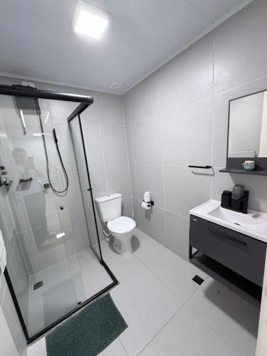a bathroom with a shower and a toilet and a sink at Apartamento 2 quartos na baixada in São Vicente