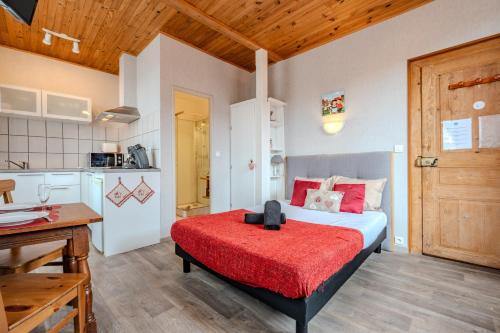 a bedroom with a bed with a red blanket at PINOT GRIS - Charmant studio au cœur du vignoble - parking gratuit in Riquewihr