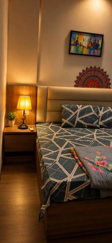 a bedroom with a bed and a lamp on a night stand at Arya homestay in Greater Noida