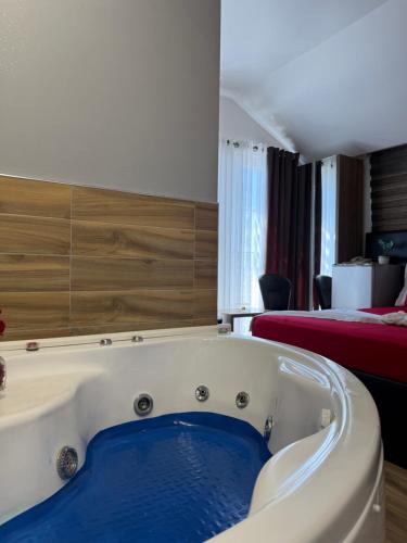 a bath tub in a hotel room with a bed at Hotel Golden in Shkodër