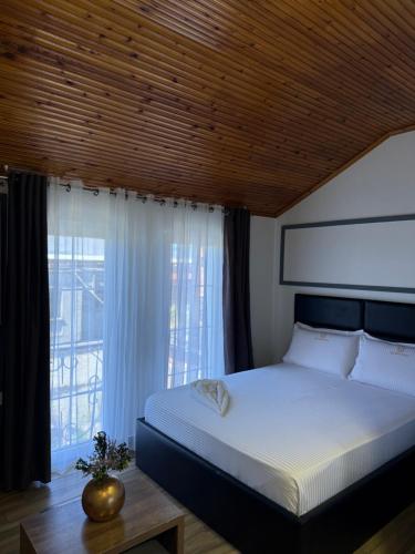 a bedroom with a large bed and a window at Hotel Golden in Shkodër