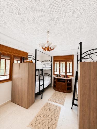 a bedroom with two bunk beds and a ceiling at Santacruz Surf Camp Morocco in Tamraght Ouzdar