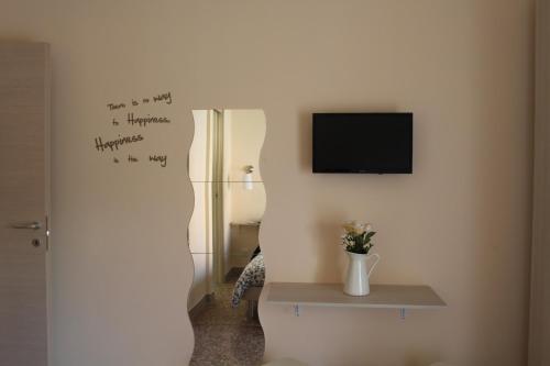 ローマにあるB&B da Giuliaのテレビ付きのお部屋、壁に花瓶