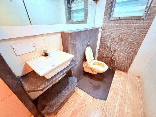 a bathroom with a sink and a toilet at Hotel Praveen International in Ulhāsnagar