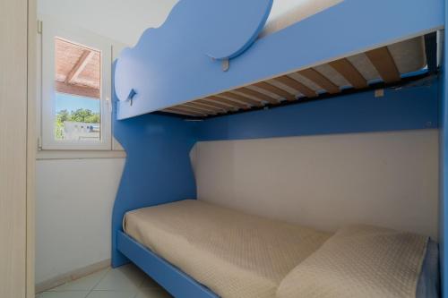 a small bedroom with a bed and a blue wall at La villetta 451 in Fontanelle