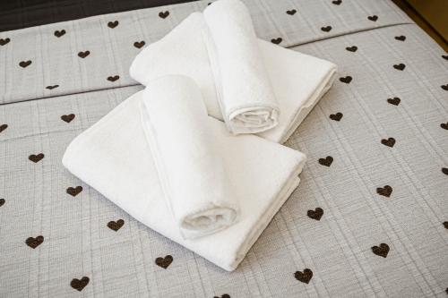 two white towels sitting on a bed with hearts at Urban Nest in Chişinău