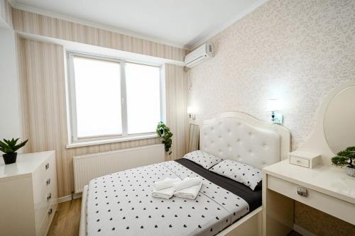 a bedroom with a white bed and a mirror at Urban Nest in Chişinău
