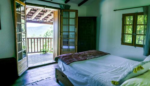 a bedroom with a bed and an open door to a balcony at Mas Lartigues in Taurinya
