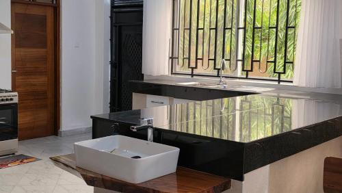 a bathroom with a sink and a stained glass window at SaltSunRetreat Villa in Ukunda