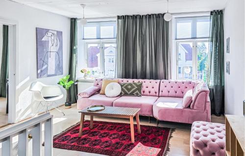 a living room with a pink couch and a table at 3 Bedroom Pet Friendly Apartment In Faaborg in Faaborg