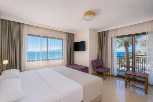 a bedroom with a bed and a view of the ocean at Altamare Hotel in Kuşadası