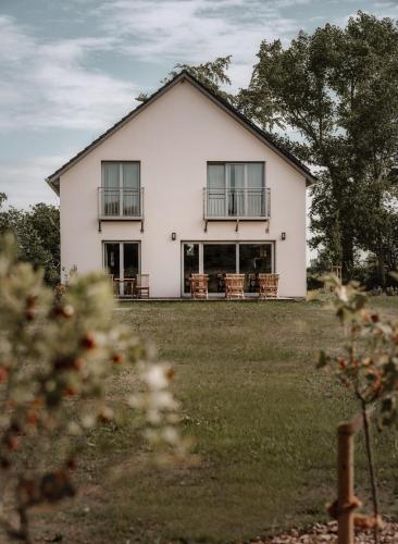 a white house with balconies on a yard at B&B Zirbenduft in Ribnitz-Damgarten