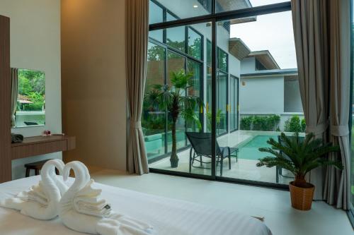 a bedroom with a bed and a view of a pool at Neon Villa in Ko Phangan