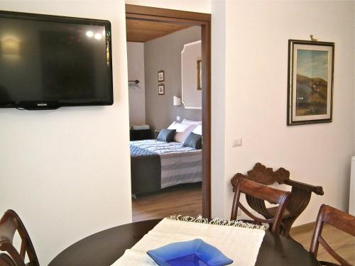 a room with a dining table and a television on a wall at Suite Umberto I in Assisi