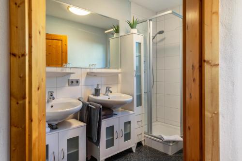 a bathroom with two sinks and a shower at Haus am Wald in Münstertal
