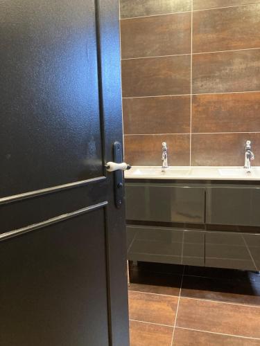 a bathroom with two sinks and a black door at Villa Bourbon Pointu - Hiking & Spa in La Plaine des Palmistes
