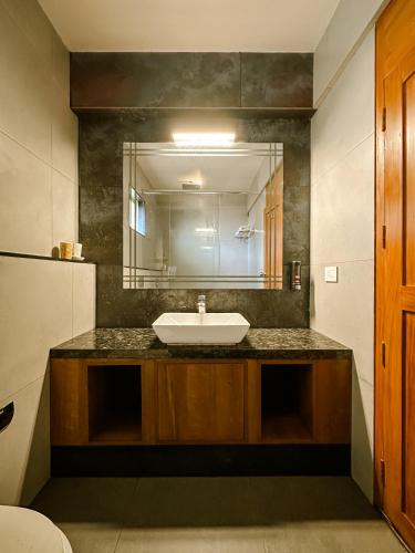 a bathroom with a sink and a mirror at Serene Slopes in Vagamon